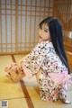 A woman in a kimono sitting on the floor.