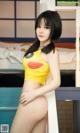A woman in a yellow bikini posing on a bed.