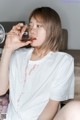 A woman sitting on a couch drinking from a wine glass.