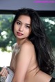A woman with long black hair is posing for a picture.