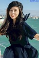 A woman in a sailor outfit posing on a boat.