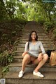 A woman sitting on the steps of a set of stairs.