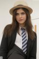 A woman in a suit and tie wearing a hat.