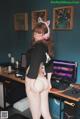 A woman in a black shirt and white panties standing in front of a computer.