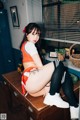 A woman sitting on top of a wooden desk.