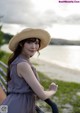 A woman in a straw hat leaning on a railing.