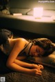 A woman laying on the floor next to a lamp.