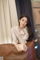 A woman sitting on top of a brown leather chair.