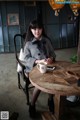 A woman sitting at a table with a cup of coffee.