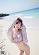 A woman in a bikini posing on the beach.