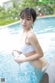 A woman in a white bikini standing in a pool.